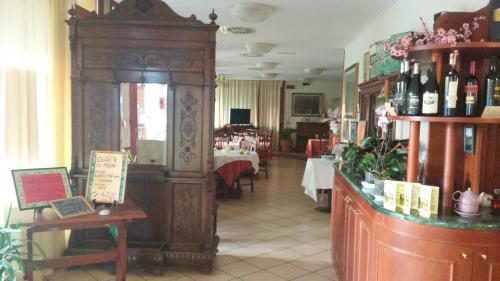 un ristorante con una sala con tavoli e bottiglie di vino di Hotel Due Fontane a Casalpusterlengo