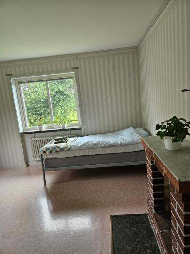 a bedroom with a bed and a window at Örnsro Boende och Ställplatser in Skara
