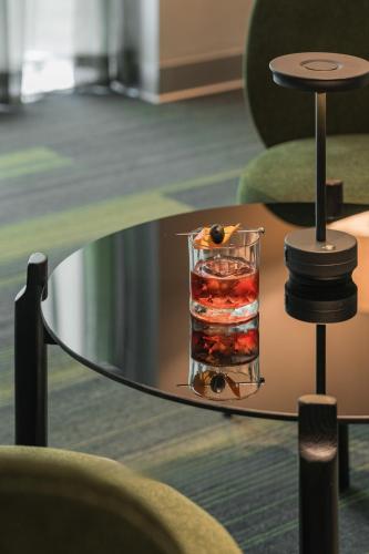a glass table with a drink on top of it at Signature by M Village Thợ Nhuộm in Hanoi