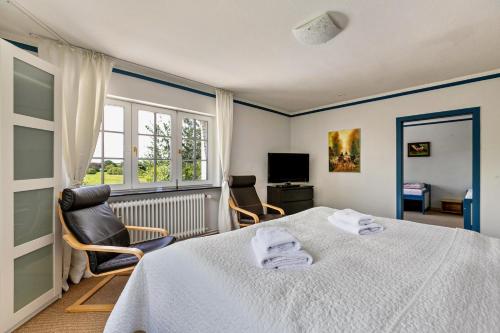 a bedroom with a bed and two chairs and a window at Austernfischer Haus in Pellworm