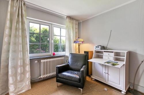 a room with a chair and a desk and a window at Austernfischer Haus in Pellworm