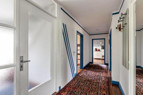 a hallway with blue and white walls and a door at Austernfischer Haus in Pellworm