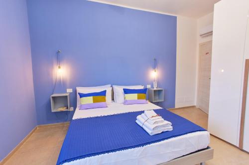 a blue bedroom with a bed with towels on it at Napodano Apartments - Napoli Salerno in Sant'Egidio del Monte Albino