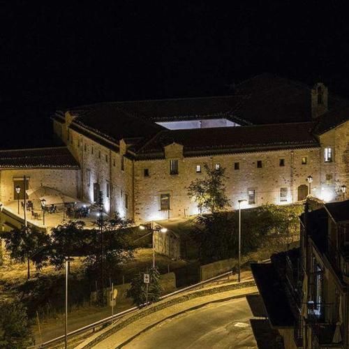 a large stone building with a street at night at Al Convento in San Mauro Castelverde