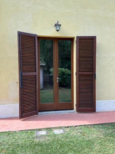 a door with wooden shutters on a building at The Grapevine by MANVI in Montepulciano