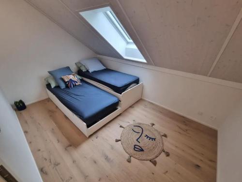 an attic bedroom with two beds and a window at Maison neuve indépendante louée spécialement pour les vacances in Les Pléiades