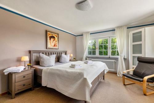 a bedroom with a bed and a chair and a window at Austernfischer Haus in Pellworm