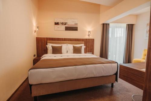 a hotel room with a large bed and a window at PENSIUNEA GAMBRINUS **** in Miercurea-Ciuc