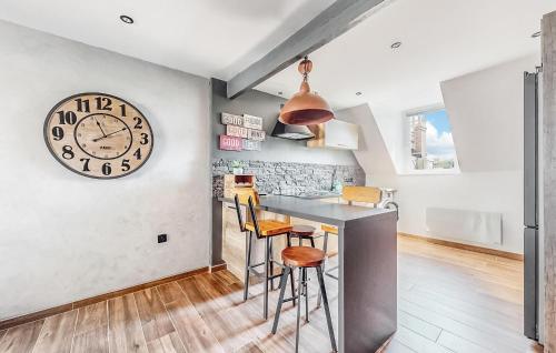 une cuisine avec un comptoir et une horloge au mur dans l'établissement Lovely Apartment In Wimereux With Wifi, à Wimereux