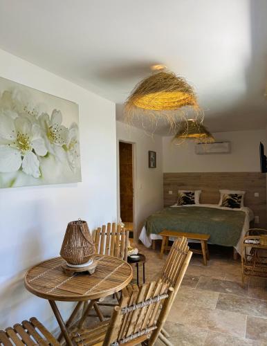 une chambre avec un lit, une table et des chaises dans l'établissement Villa Hawwah, à Sète