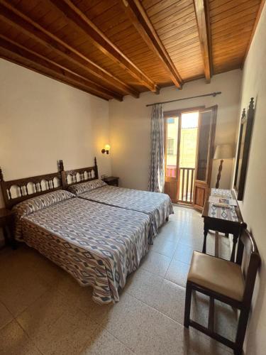 a bedroom with a large bed and a wooden ceiling at Hostal Restaurante Playa in Colònia de Sant Jordi
