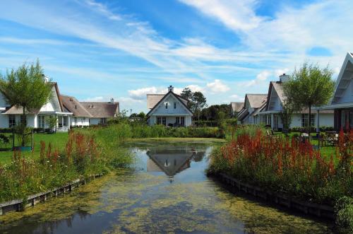 a river in a residential neighborhood with houses at Buitenplaats Witte Raaf aan Zee in Noordwijk