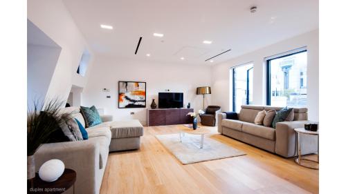a living room with two couches and a tv at Welcome London - The York in London