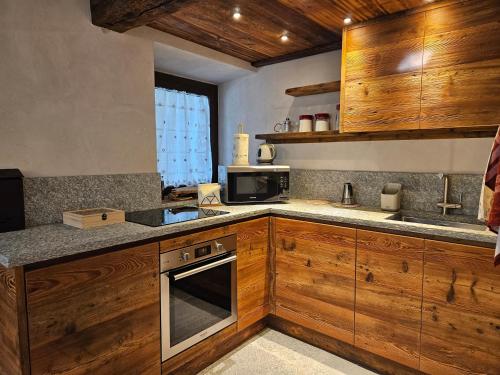 a kitchen with wooden cabinets and a microwave at Maison Martin in Pré-Saint-Didier