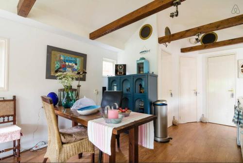 een eetkamer met een tafel en een blauwe kast bij Fisherman's Home in Vinkeveen