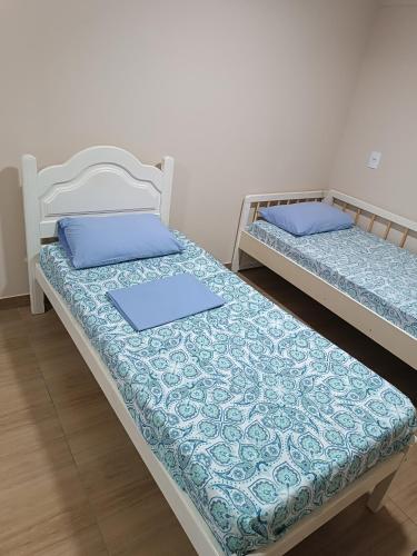 two beds sitting next to each other in a room at Cobertura em Aperibé in Aperibé