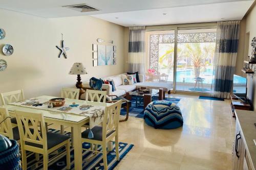 a living room with a table and chairs at Mangroovy - Elgouna Authentic Designer shared home 2 BDR each with private bathroom for Kitesurfers with Pool View & Beach Access in Hurghada