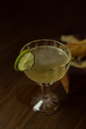 a drink with a lime in a glass on a table at Pousada Cantelli in Bento Gonçalves