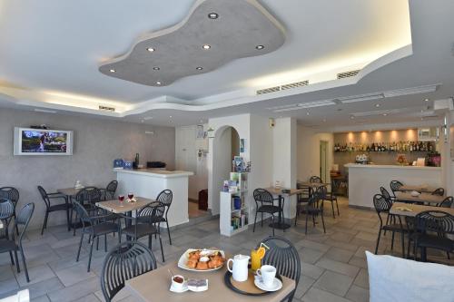 纳乌萨亚力山德罗斯公寓酒店的一家有桌椅和酒吧的餐厅