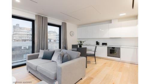 a living room with a couch and a kitchen at Welcome London - The York in London