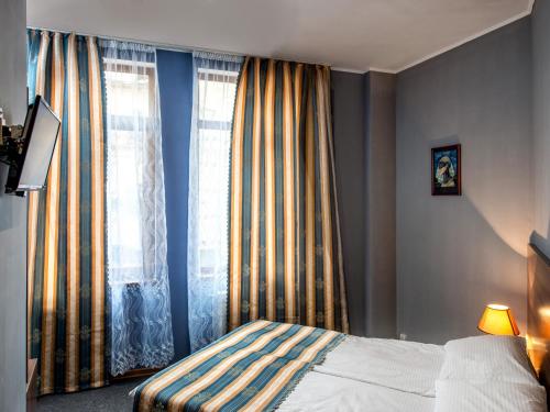 a bedroom with a bed and a window with curtains at Lviv Central Jam Hotel in Lviv