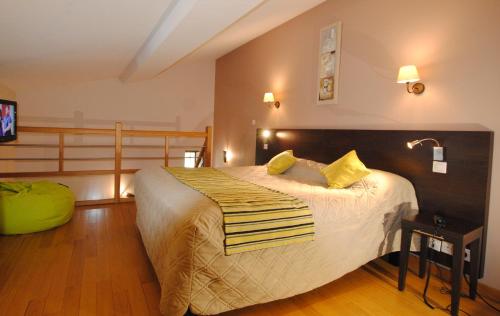 Un dormitorio con una cama grande con almohadas amarillas. en Hostellerie du Perigord Vert-Logis, en Brantôme