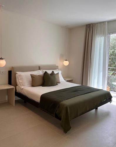 a bedroom with a large bed and a window at Vireo Rooms in Santa Maria Navarrese
