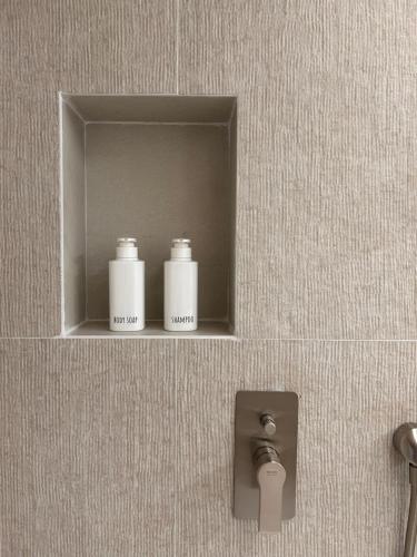 two bottles ofodorizers on a shelf in a bathroom at Vireo Rooms in Santa Maria Navarrese