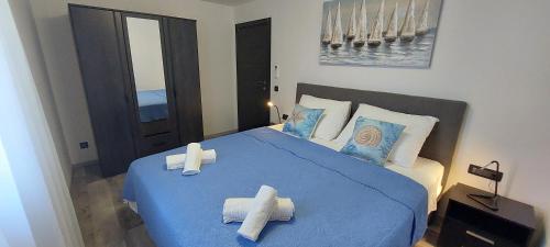 a bedroom with a blue bed with towels on it at Villa Irene in Veli Lošinj