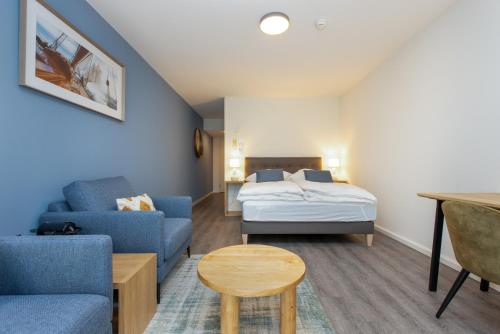 a room with a bed and a couch and a table at Tertianum Residenz Zollikerberg in Zollikerberg