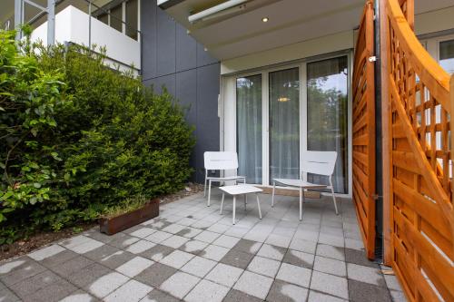 a patio with two chairs and a table at Tertianum Residenz Zollikerberg in Zollikerberg