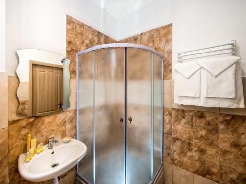 ein Bad mit einer Dusche und einem Waschbecken in der Unterkunft Lviv Central Jam Hotel in Lwiw