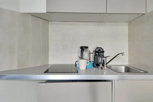 - une cuisine avec un évier et une tasse de café sur un comptoir dans l'établissement Comfort studio at Gare de l Est, à Paris