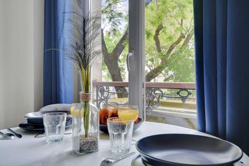 une table avec des assiettes et des verres sur une table avec une fenêtre dans l'établissement Comfort studio at Gare de l Est, à Paris