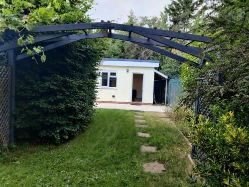 a garden with a blue archway and a white house at Chiltern Nursuries in Amersham