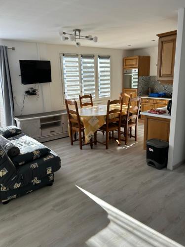 une cuisine et une salle à manger avec une table et des chaises dans l'établissement Jo et lo location, à Chastreix