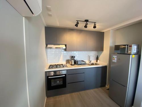 a small kitchen with a stove and a refrigerator at Cabaña 1 Lican Ray primera linea in Licán Ray