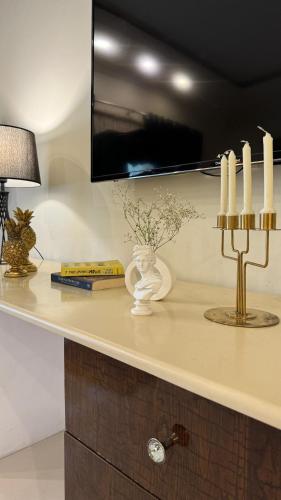 a counter top with candles and a lamp on it at Grace Boutique Hotel in Islamabad