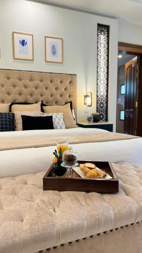 a hotel room with a bed with a tray of food on it at Grace Boutique Hotel in Islamabad