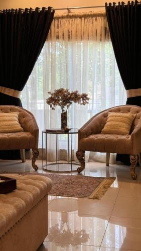 a living room with two couches and a table and a window at Grace Boutique Hotel in Islamabad