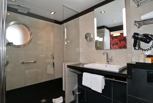 a bathroom with a sink and a shower at Hôtel Hor Europe in Paris