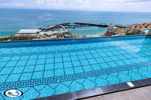 a swimming pool with a view of the ocean at Oscar Seaview Apartment in Phu Quoc
