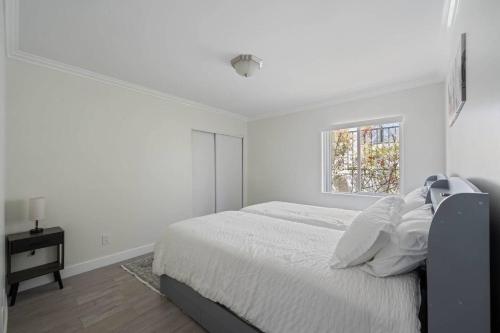 a white bedroom with a bed and a window at Serene Home in Central Burbank in Burbank