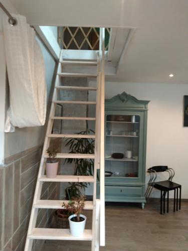 a white ladder in a room with plants at Easy house location 2 in Sainte-Marie-du-Mont