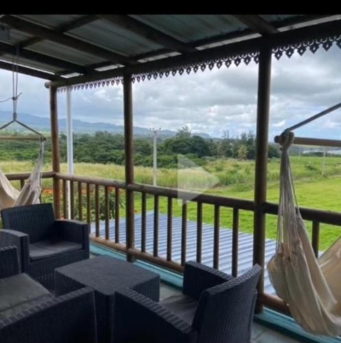a porch with hammocks and a view of the water at Ocean View Villa at Bel Ombre Mauritius in Bel Ombre
