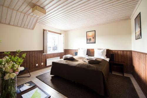 ein Schlafzimmer mit einem Bett in einem Zimmer in der Unterkunft Grinda Wärdshus in Grinda