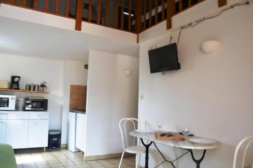 un salon avec une table et une télévision au mur dans l'établissement Appartement 2 Pièces mezzanine 5 couchages ARGELES SUR MER AR190-022, à Argelès-sur-Mer