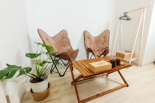two chairs and a table in a room with a plant at -Hideaway Miyakojima- 都島駅徒歩3分梅田10分長期滞在OK都会の静かな隠れ家 in Osaka