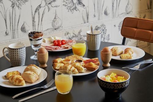 a table with plates of breakfast foods and drinks at Villa Bougainville by Happyculture in Nice