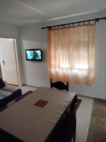 a living room with a table and a window at Apartman M in Trebinje
